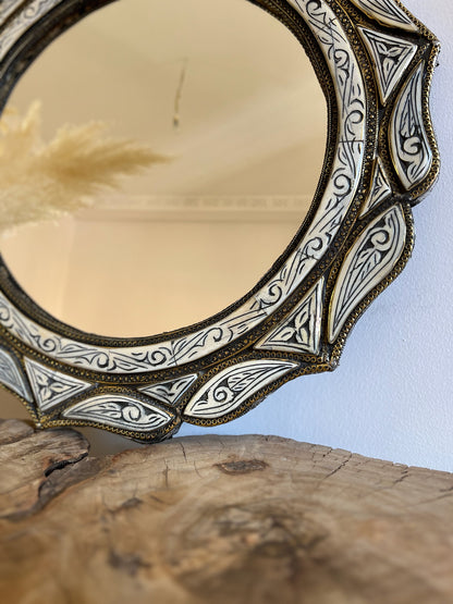 a mirror sitting on top of a wooden table