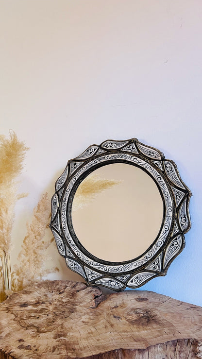 a mirror sitting on top of a wooden table