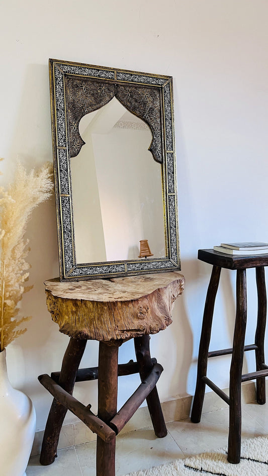 a mirror sitting on top of a wooden stool