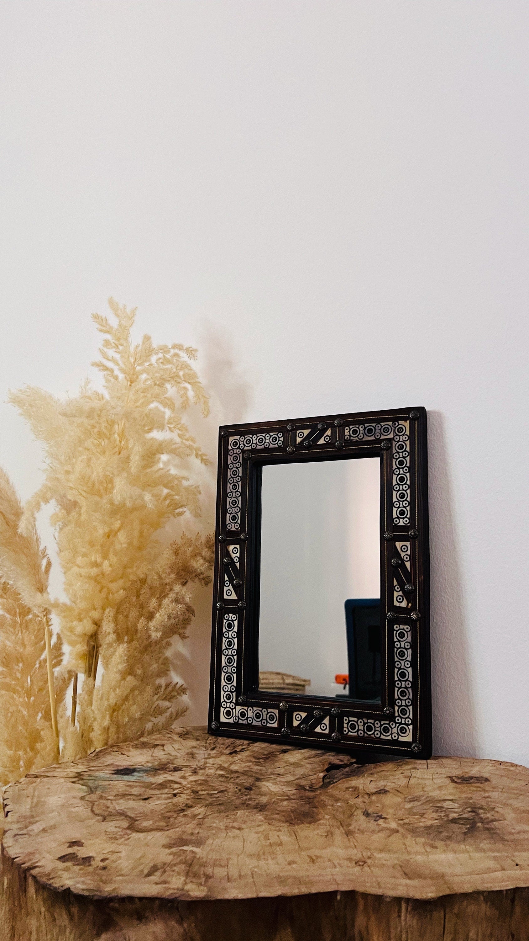 a mirror sitting on top of a wooden table