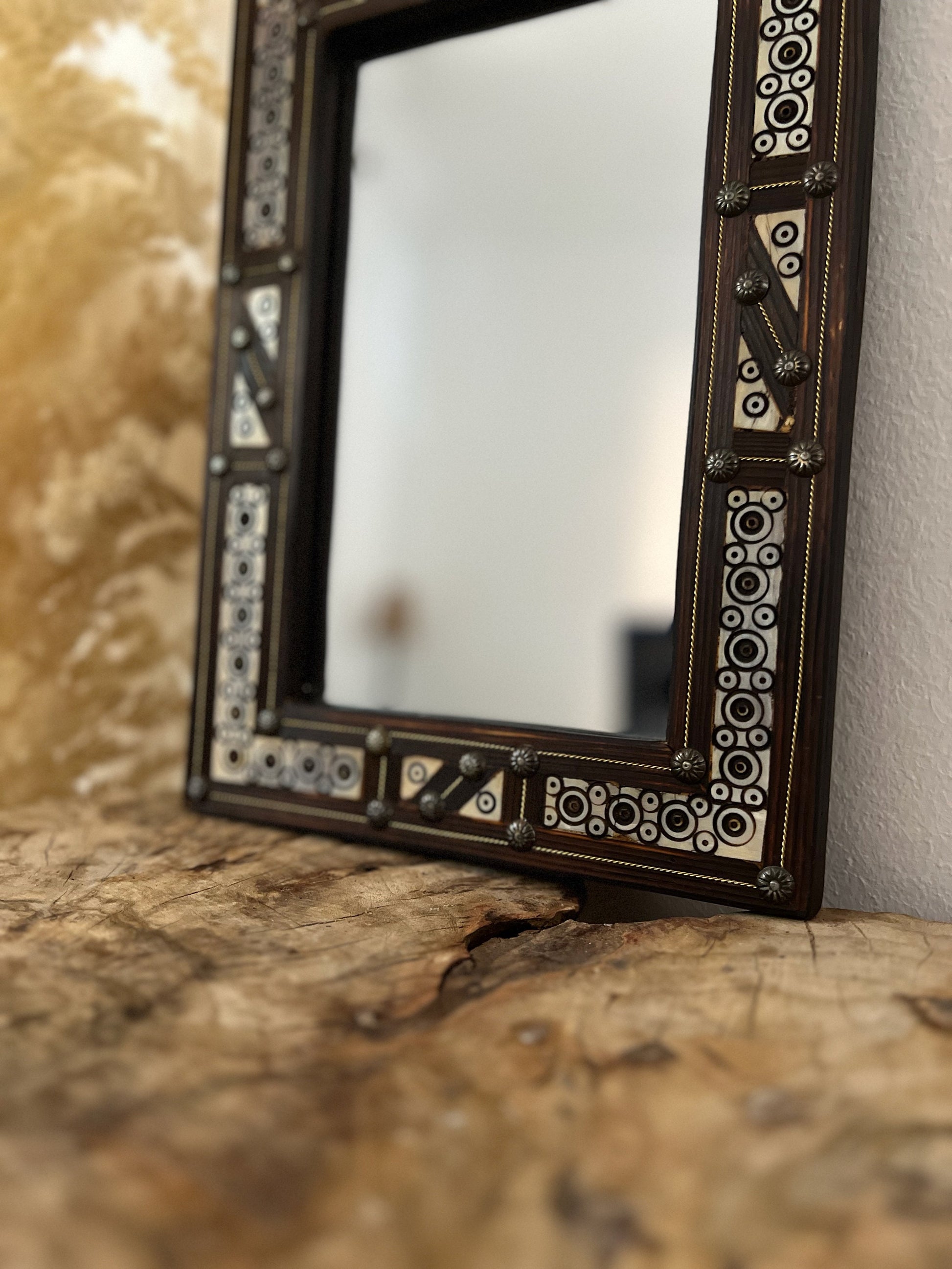 a mirror sitting on top of a wooden table