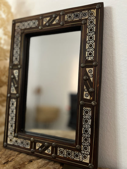 a mirror sitting on top of a wooden table