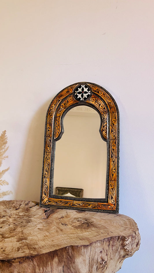 a mirror sitting on top of a wooden table