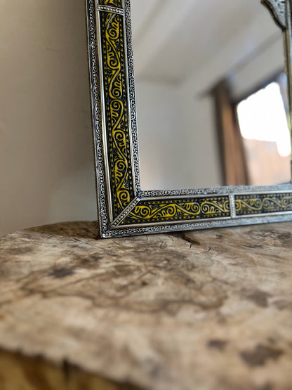 a mirror sitting on top of a wooden table