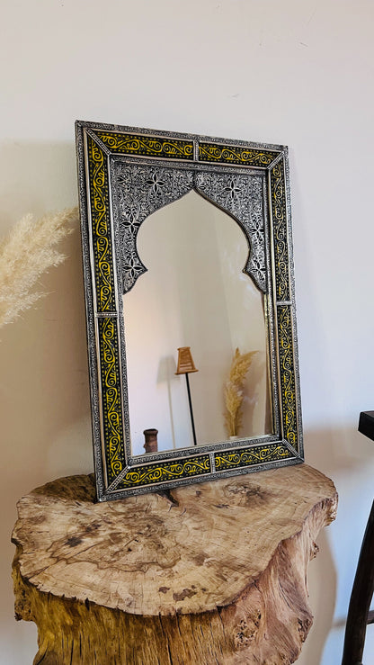 a mirror sitting on top of a wooden table