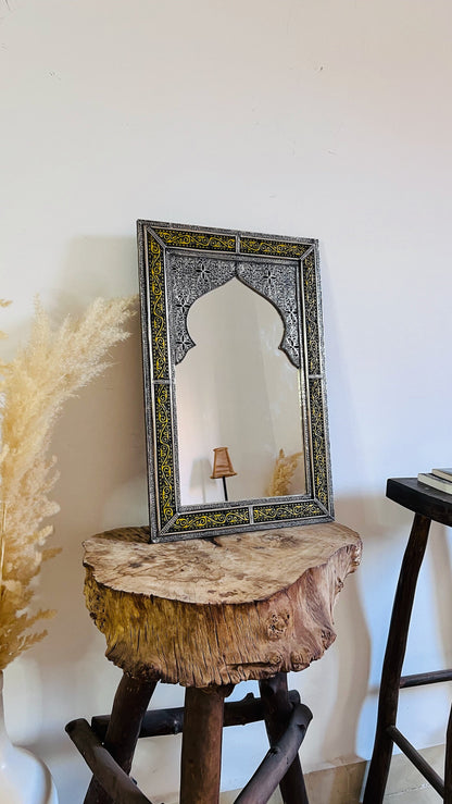 a mirror sitting on top of a wooden stool