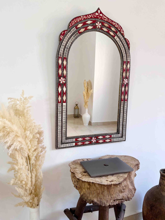 a laptop computer sitting on a wooden stool in front of a mirror