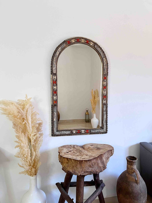 a wooden stool sitting next to a mirror on a wall