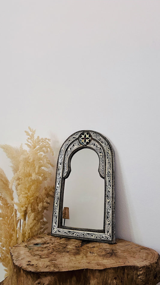 a mirror sitting on top of a wooden table