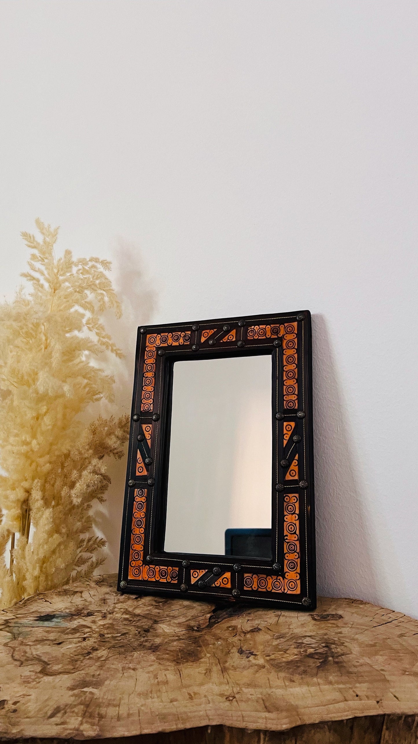 a mirror sitting on top of a wooden table