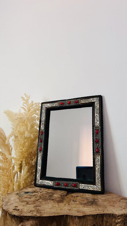 a mirror sitting on top of a wooden table