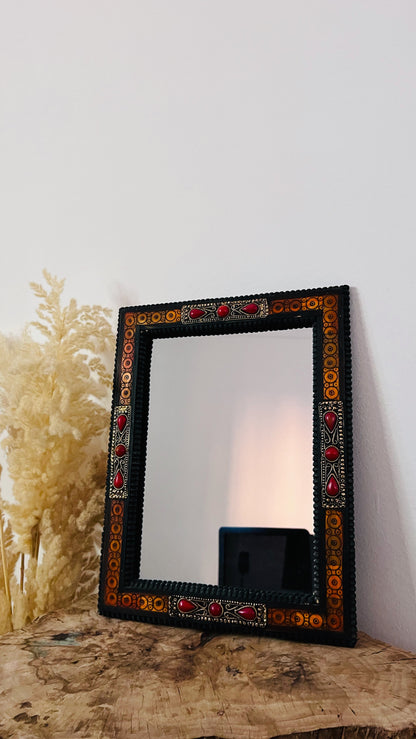 a mirror sitting on top of a wooden table