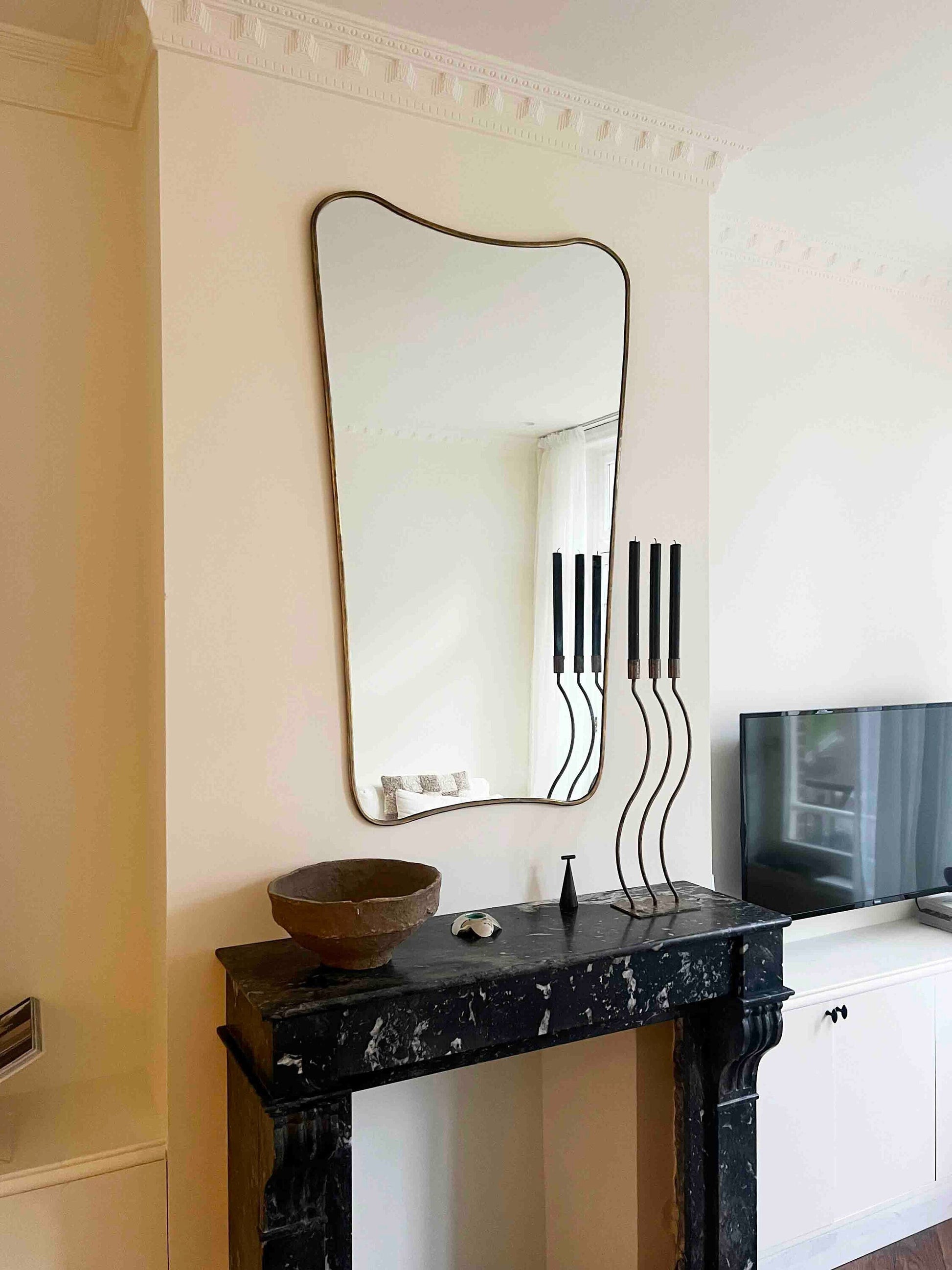 a black table with a mirror and a bowl on it